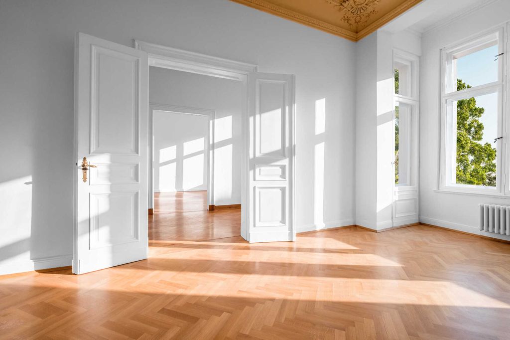 Leerer Raum mit Holzboden und weißen Wänden